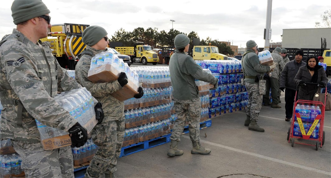 Military personnel distribute relief supplies