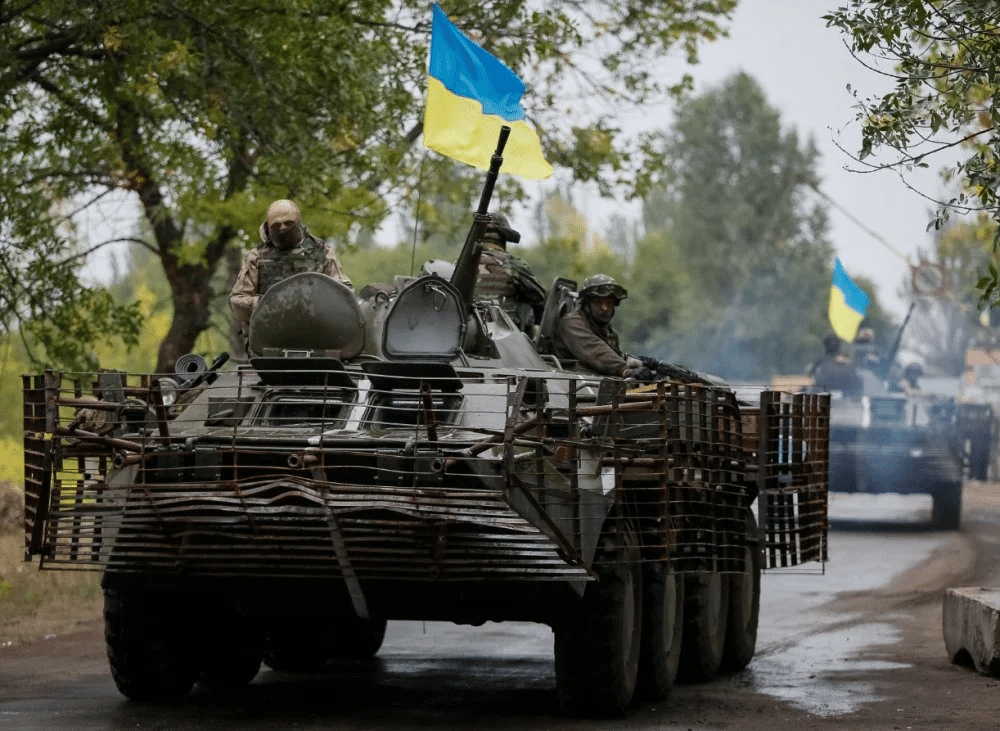 Armored vehicles travel a road during the Ukraine-Russia conflict