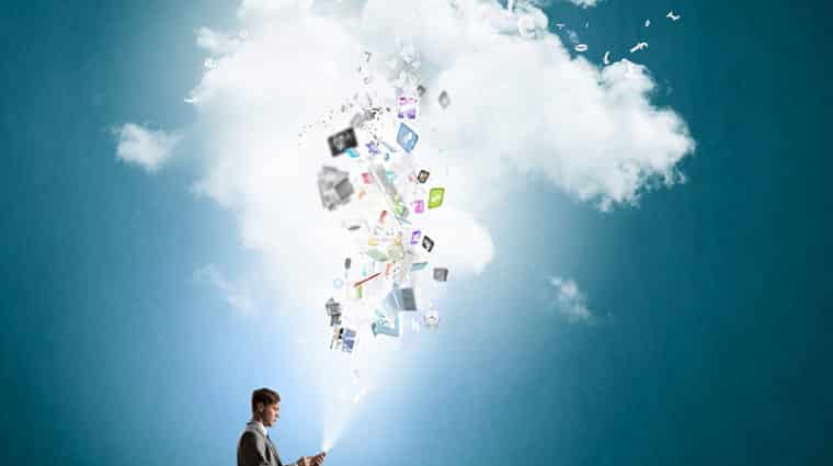 Young businessman sitting on cloud with mobile phone in hands