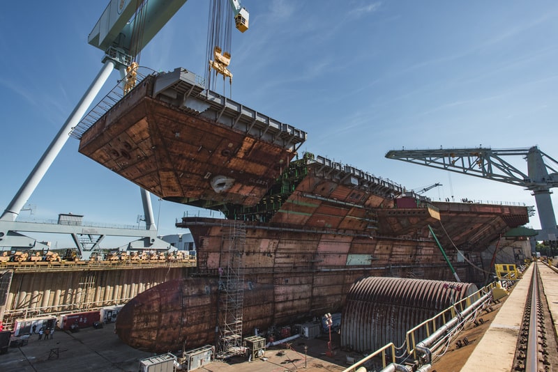 190710-N-N2201-100
NEWPORT NEWS, Va. (July 10, 2019) The upper bow unit of the future  aircraft carrier USS John F. Kennedy (CVN 79) is fitted to the primary structure of the ship, July 10, 2019, at Huntington Ingalls Industries Newport News Shipbuilding. John F. Kennedy is the second Gerald R. Ford-class aircraft carrier and the second aircraft carrier to be named after the 35th president. The 1,096-foot hull is longer than three football fields and more than 3,000 shipbuilders and 2,000 suppliers from across the country are supporting construction of the ship. The christening for John F. Kennedy is scheduled for late 2019. (U.S. Navy photo courtesy of Huntington Ingalls Industries by Matt Hildreth/Released)